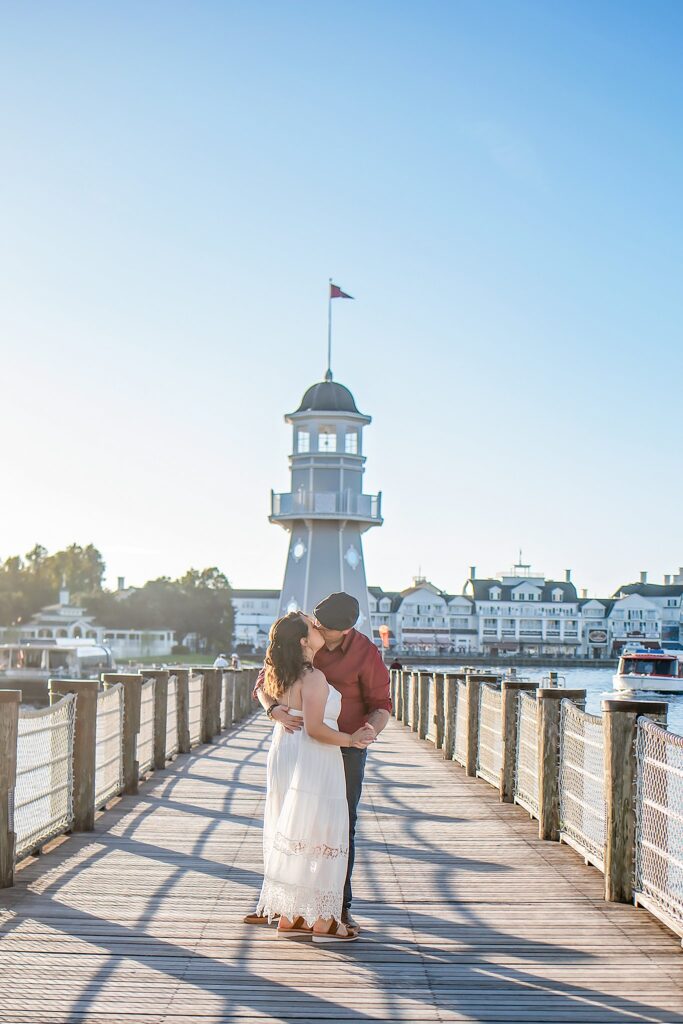 couple kissing in front of lighthouse at their Disney Engagement Photos