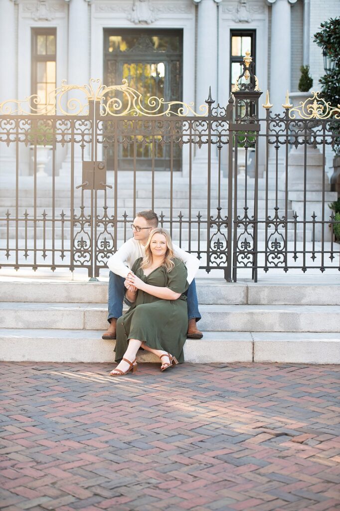 couple sitting in front of mansion at golden hour