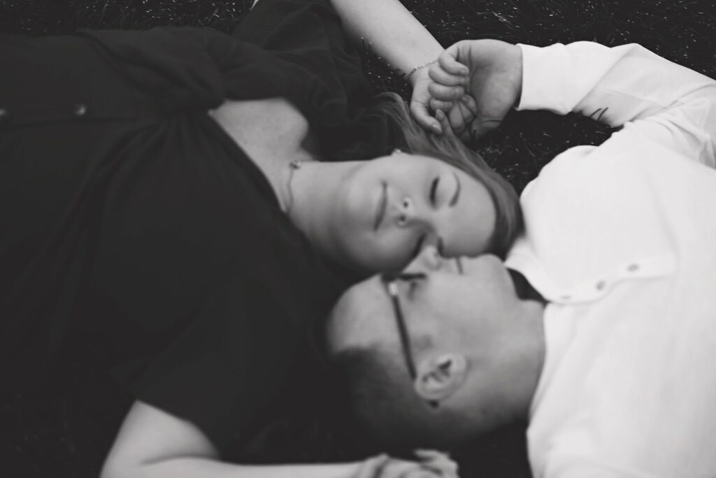 couple laying down with eyes closed at their savannah georgia engagement photos