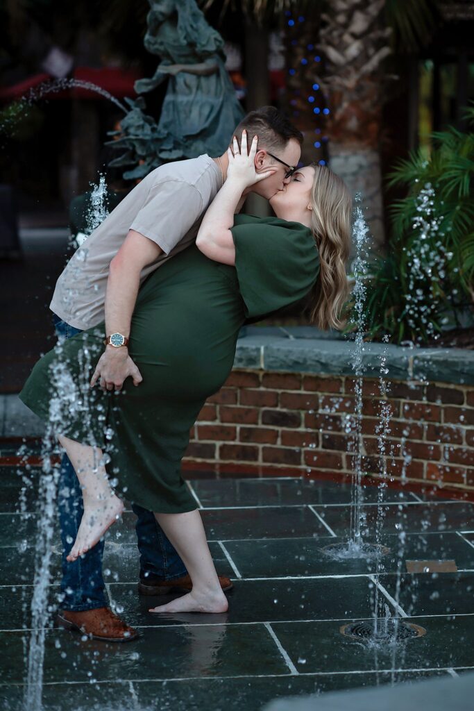 couple kissing in fountain in their savannah georgia engagement photos