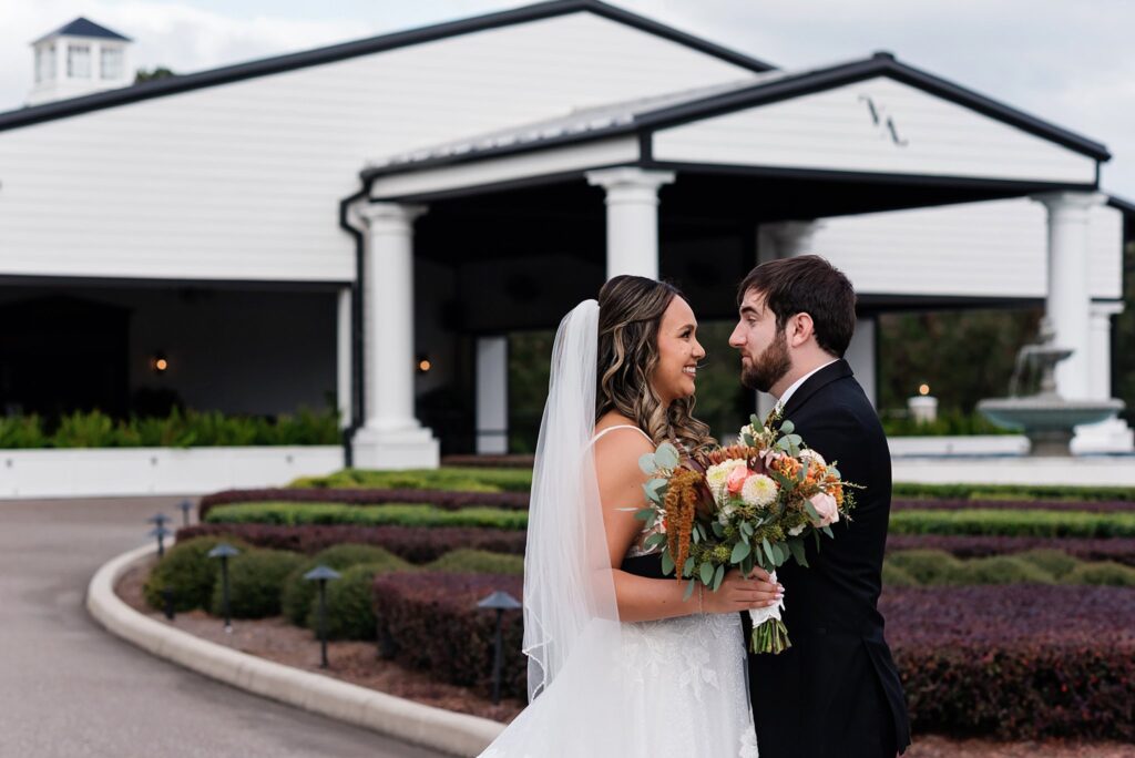 bride and groom in front of venue. Wedding photography styles