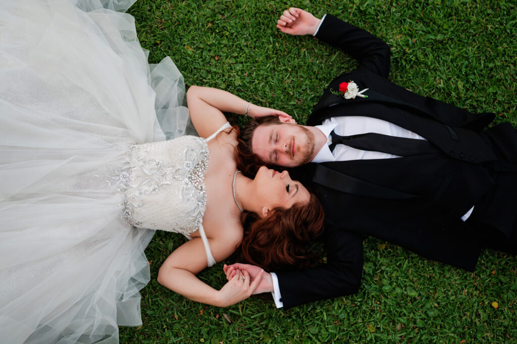 bride and groom laying down facing each other