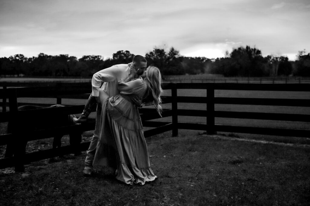 Couple kissing on the farm at sunset