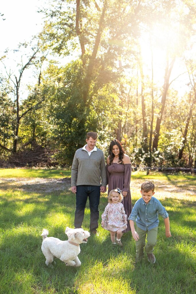 family playing with dog at golden hour 