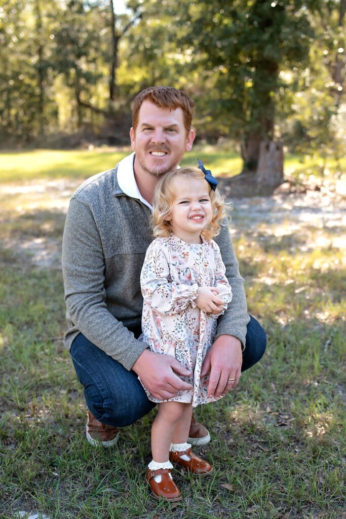 father and daughter smiling at the camera