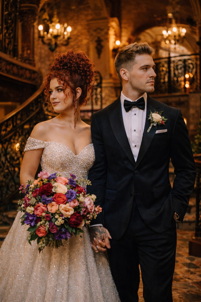a bride and groom holding hands at the cruz building wedding venue on their wedding day