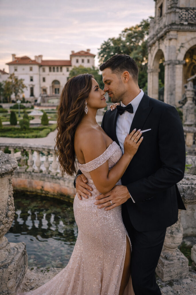 vizcaya museum and garden engagement session in the spring in miami florida. a couple is holding each other looking at each other