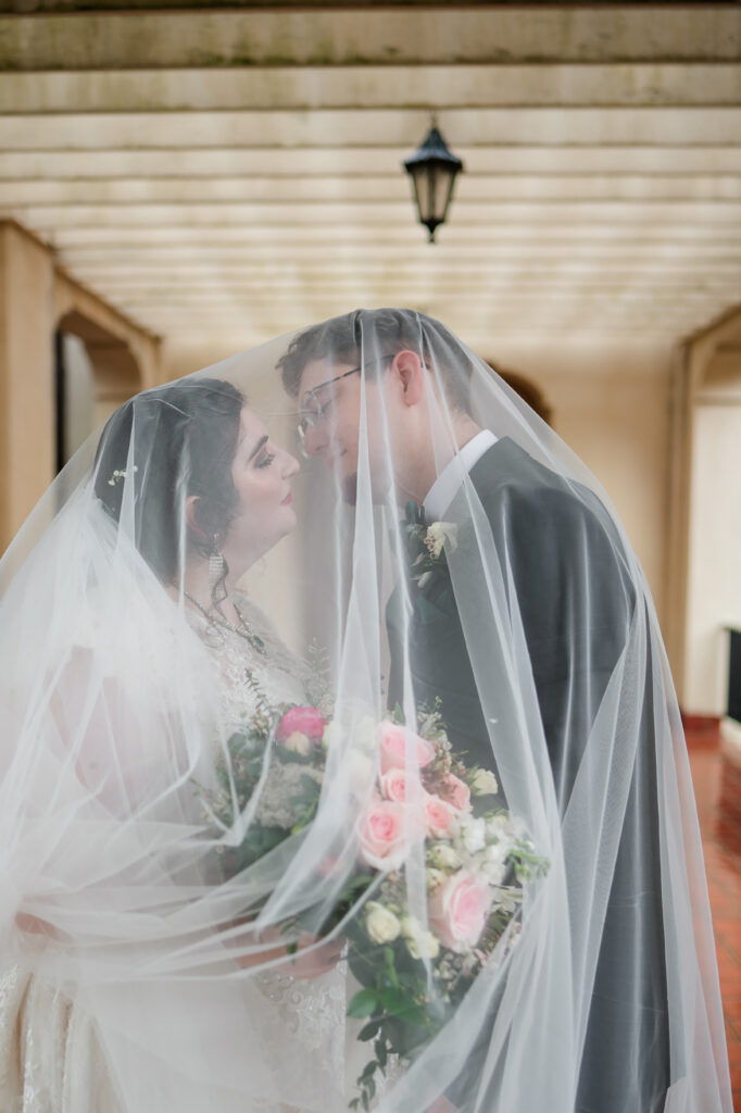 Bride and groom embracing under the archway at their Thomas Center wedding in Gainesville Florida